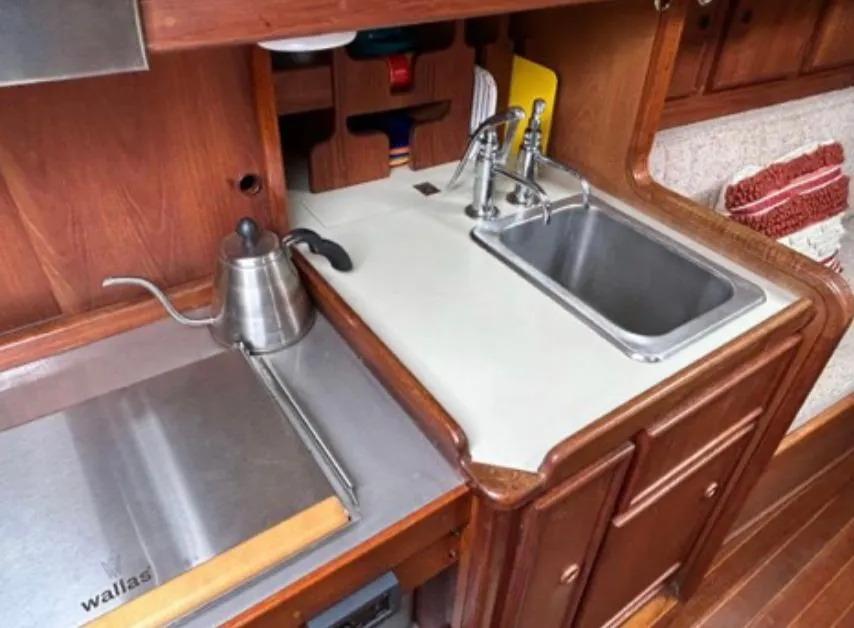 1982 Bristol Channel Cutter 28 galley with sink, stove, and wooden cabinetry.