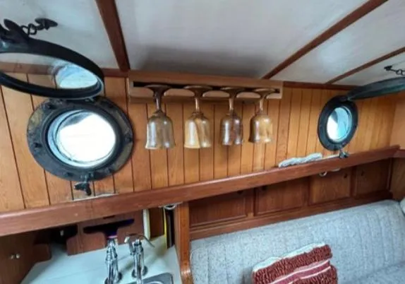 Interior of 1982 Bristol Channel Cutter 28 with portholes and hanging glasses.
