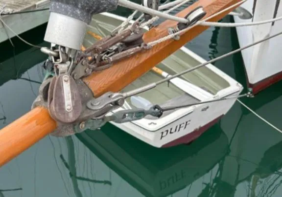 Bristol Channel Cutter 28 sailboat detail, 1982 model, with dinghy named "Puff" in water.