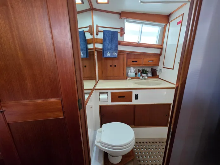 Kokomo Yacht Photos Pics Bathroom interior of 1993 Grand Banks 42 Classic yacht, featuring wooden cabinetry and nautical decor.