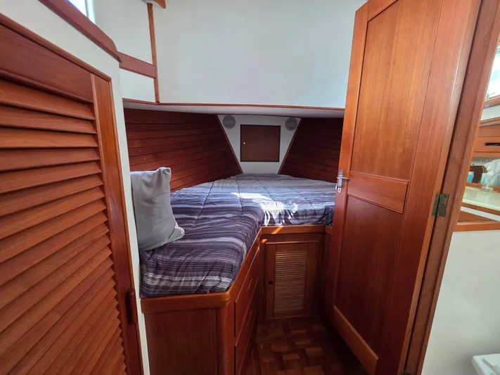 Kokomo Yacht Photos Pics Cozy cabin interior of 1993 Grand Banks 42 Classic with wooden finish and comfortable bedding.