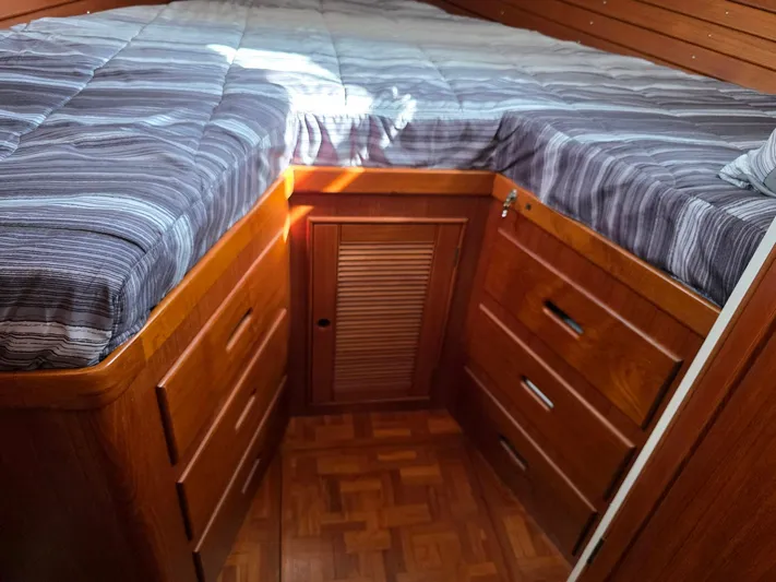 Kokomo Yacht Photos Pics Cozy cabin interior of 1993 Grand Banks 42 Classic with wooden drawers and striped bedding.