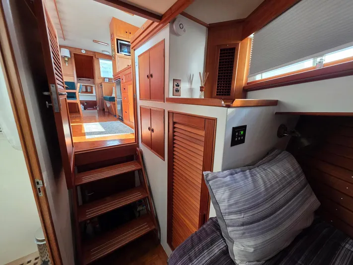 Kokomo Yacht Photos Pics Interior of a 1993 Grand Banks 42 Classic yacht, featuring wooden cabinetry and cozy sleeping area.