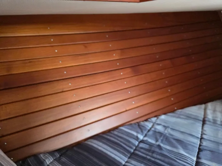 Kokomo Yacht Photos Pics Interior of 1993 Grand Banks 42 Classic with wooden paneling and striped bedding.