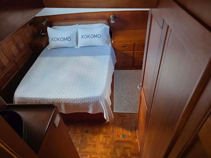 Kokomo Yacht Photos Pics Cozy bedroom in 1993 Grand Banks 42 Classic yacht with wooden interior and "KOKOMO" pillows.