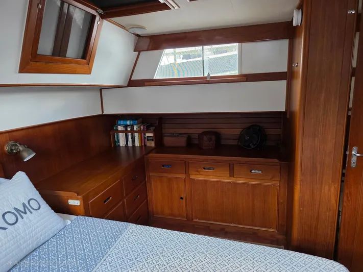 Kokomo Yacht Photos Pics Cozy cabin interior of 1993 Grand Banks 42 Classic yacht with wooden furnishings and books.