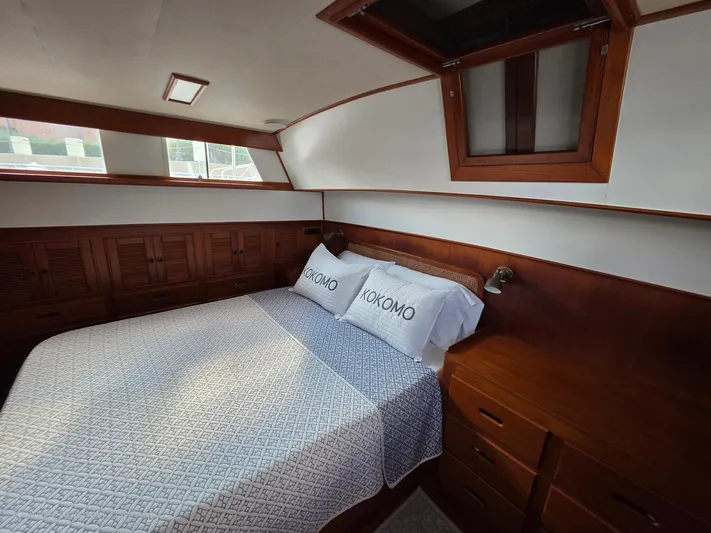 Kokomo Yacht Photos Pics Cozy bedroom interior of 1993 Grand Banks 42 Classic yacht with wooden cabinetry and bedding.