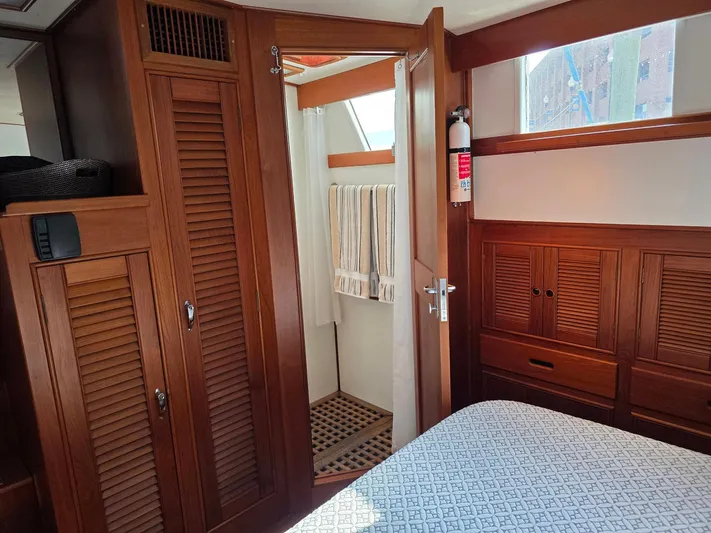 Kokomo Yacht Photos Pics 1993 Grand Banks 42 Classic interior with wooden cabinetry, bed, and bathroom entrance.