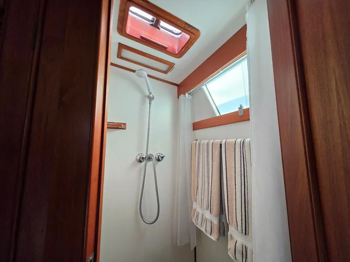 Kokomo Yacht Photos Pics Shower area in 1993 Grand Banks 42 Classic yacht with wooden accents and striped towels.