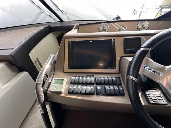  Yacht Photos Pics Control panel of a 2017 Prestige 500 yacht with steering wheel and navigation display.