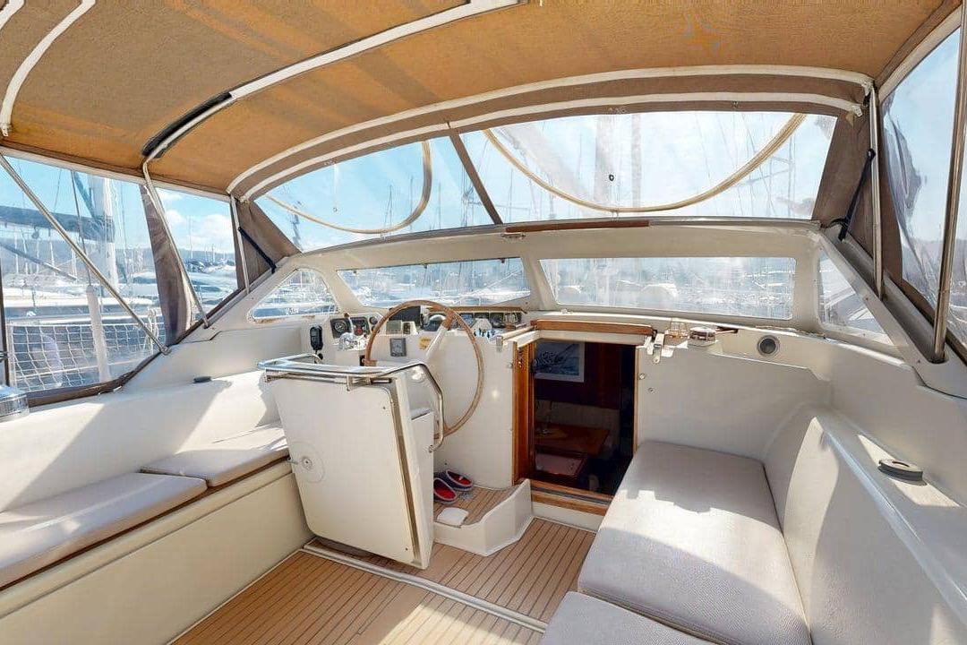 Cockpit of 2001 Amel Super Maramu 2000 sailboat with wooden accents and seating.