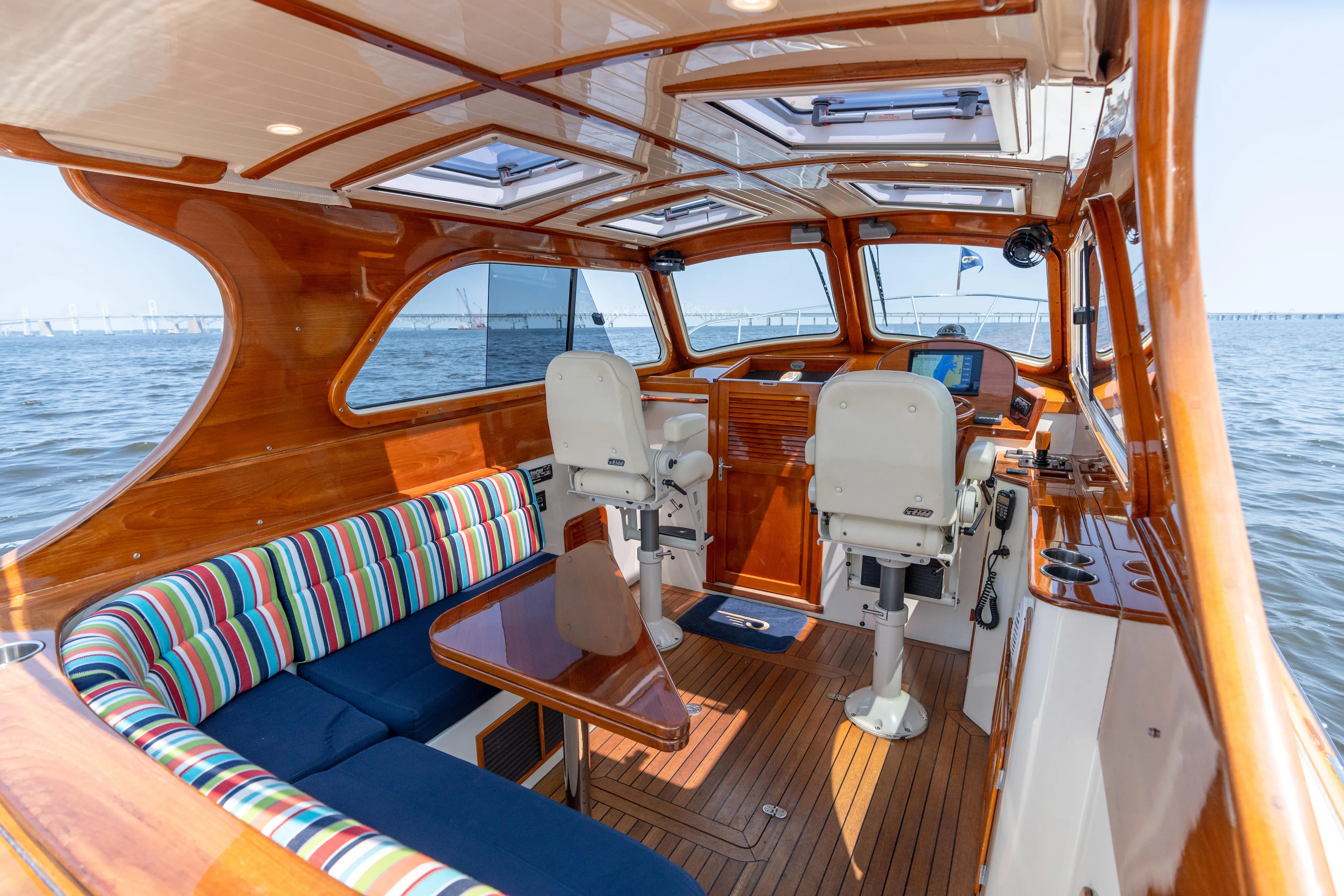 Sometimes Yacht Photos Pics Luxurious 2007 Hinckley Picnic Boat EP interior with wood finish and striped seating on the water.