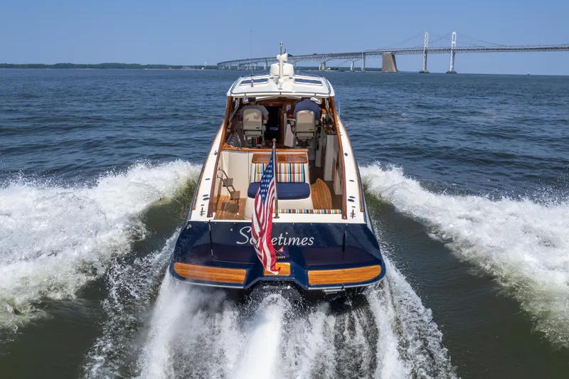 Sometimes Yacht Photos Pics 2007 Hinckley Picnic Boat EP cruising on water near a bridge, rear view.