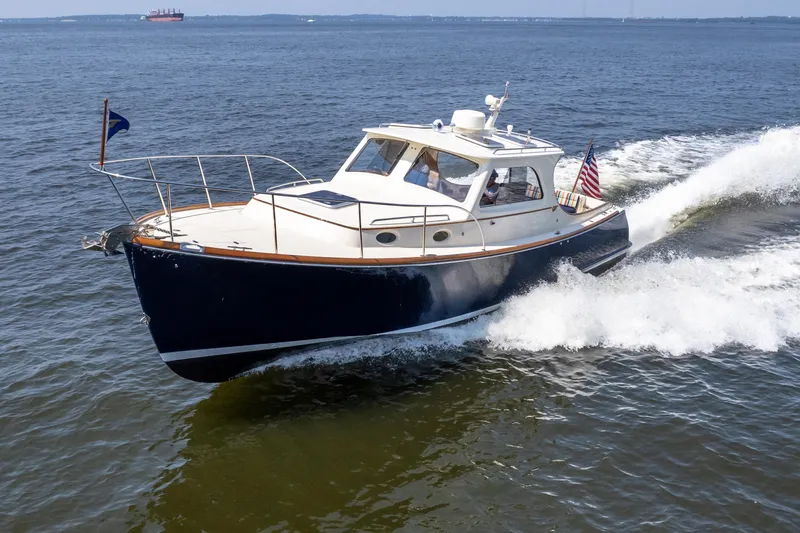 Sometimes Yacht Photos Pics 2007 Hinckley Picnic Boat EP cruising on open water, displaying sleek design and American flag.
