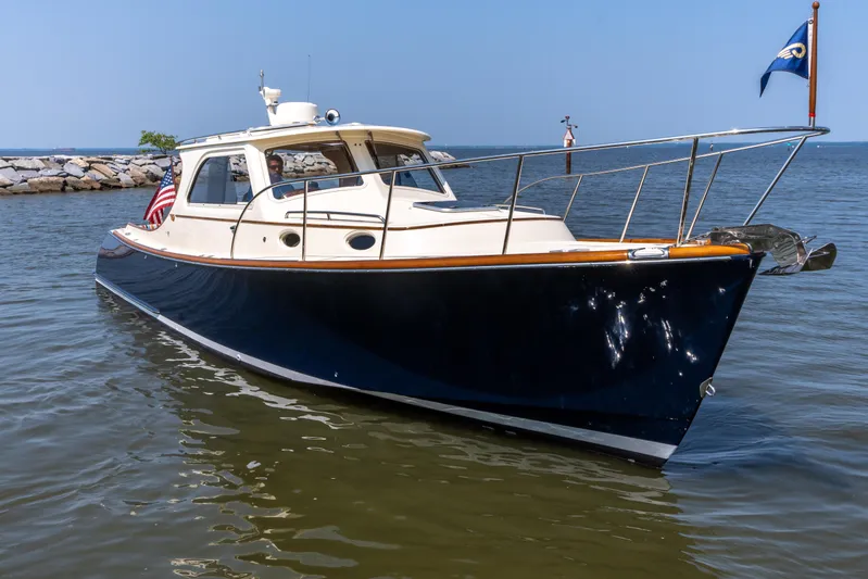 Sometimes Yacht Photos Pics 2007 Hinckley Picnic Boat EP on calm water, featuring sleek design and American flag.