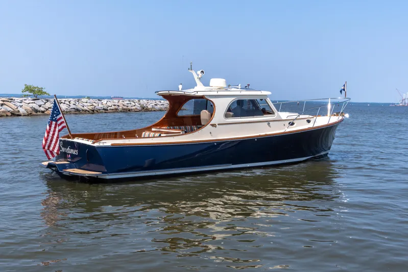 Sometimes Yacht Photos Pics 2007 Hinckley Picnic Boat EP on calm water, featuring classic design and American flag.