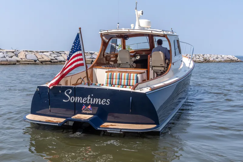 Sometimes Yacht Photos Pics 2007 Hinckley Picnic Boat EP cruising with American flag, named "Sometimes," in a serene harbor setting.