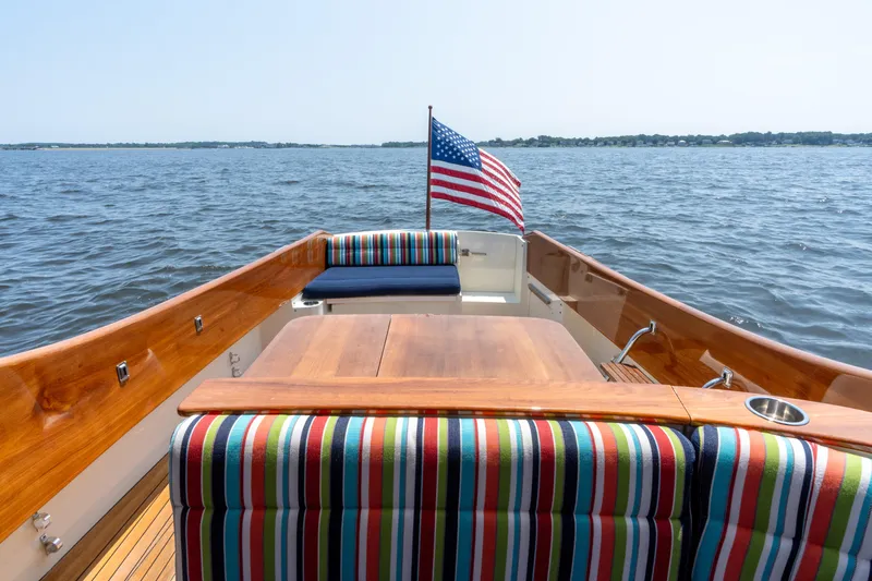Sometimes Yacht Photos Pics 2007 Hinckley Picnic Boat EP with striped seating, American flag, on open water.