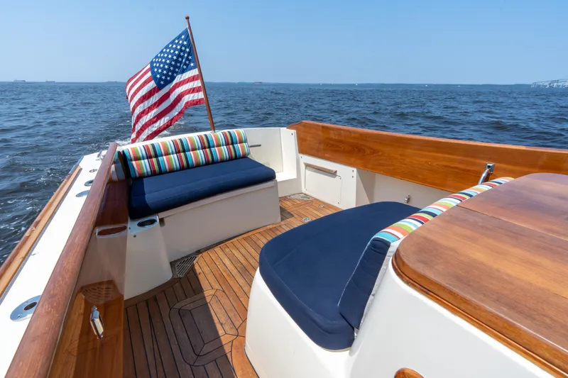 Sometimes Yacht Photos Pics 2007 Hinckley Picnic Boat EP with American flag, wooden deck, and colorful seating on open water.