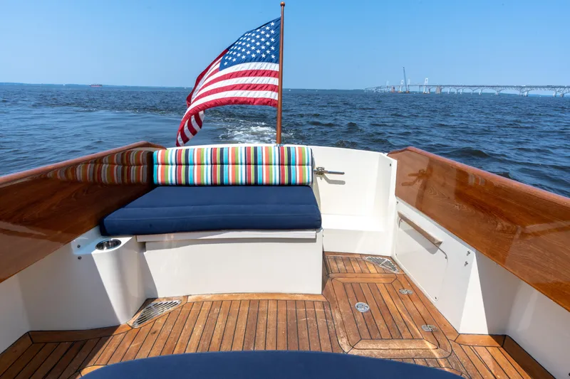 Sometimes Yacht Photos Pics 2007 Hinckley Picnic Boat EP with American flag, wooden deck, and colorful seating on open water.