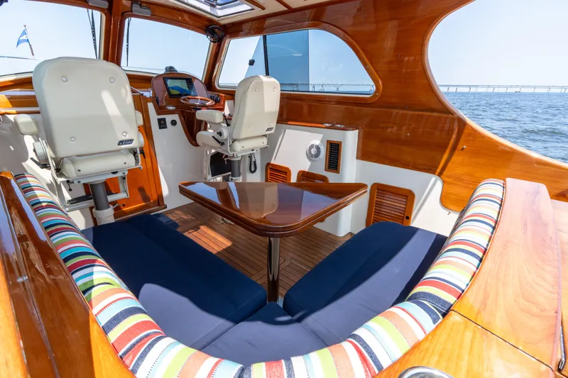 Sometimes Yacht Photos Pics Luxurious 2007 Hinckley Picnic Boat EP interior with striped seating and wooden accents.