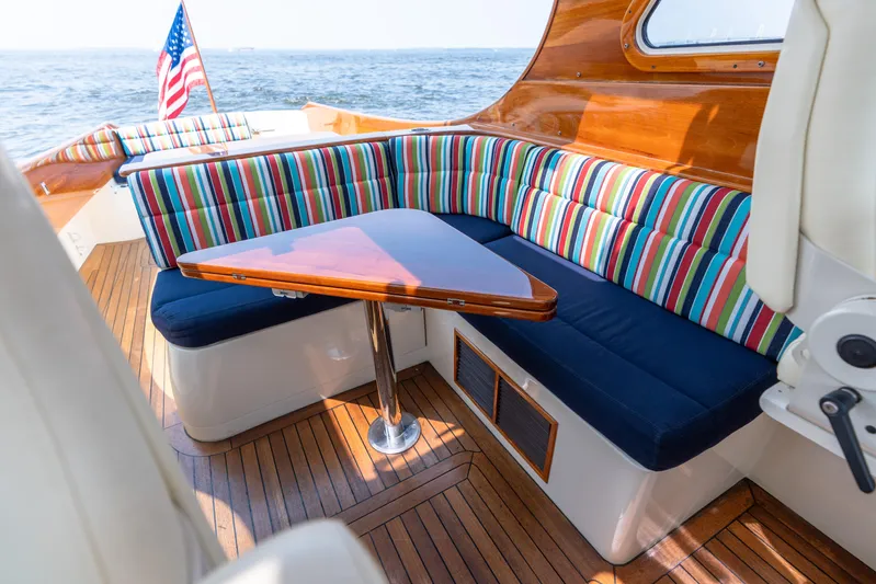 Sometimes Yacht Photos Pics 2007 Hinckley Picnic Boat EP interior with striped seating and wooden table.