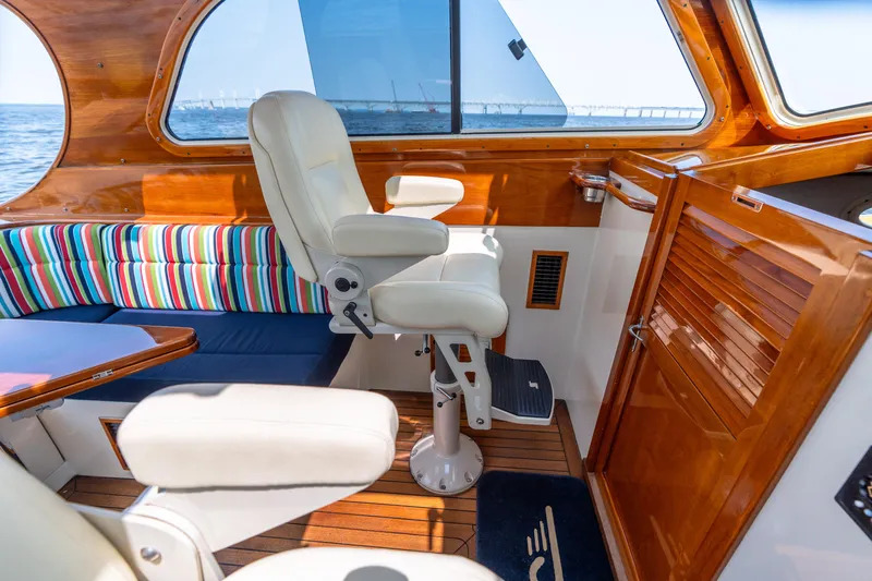 Sometimes Yacht Photos Pics Interior of 2007 Hinckley Picnic Boat EP with striped seating and wooden finishes.