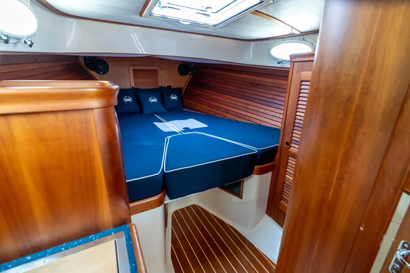 Sometimes Yacht Photos Pics Luxurious 2007 Hinckley Picnic Boat EP cabin with wooden interior and cozy bedding.
