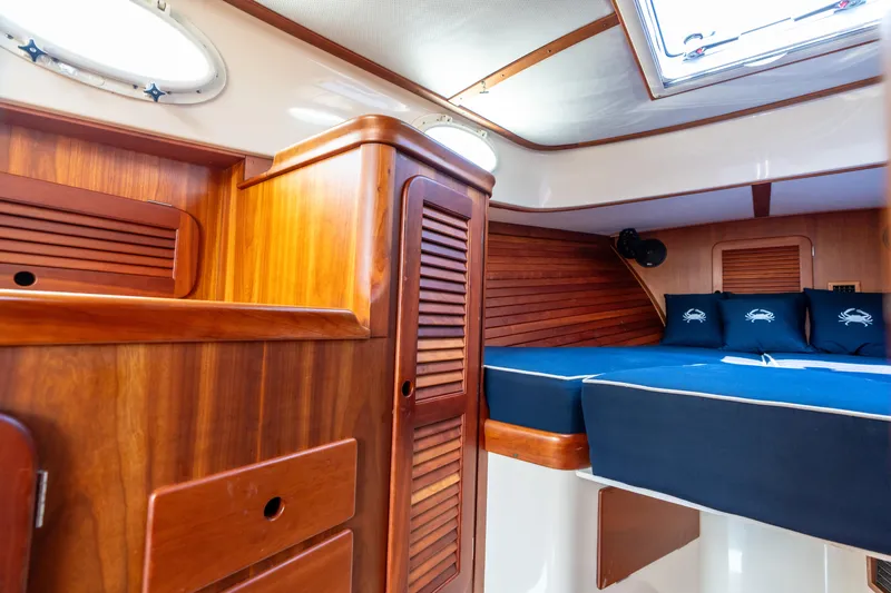 Sometimes Yacht Photos Pics 2007 Hinckley Picnic Boat EP cabin with wooden interior and blue bedding.