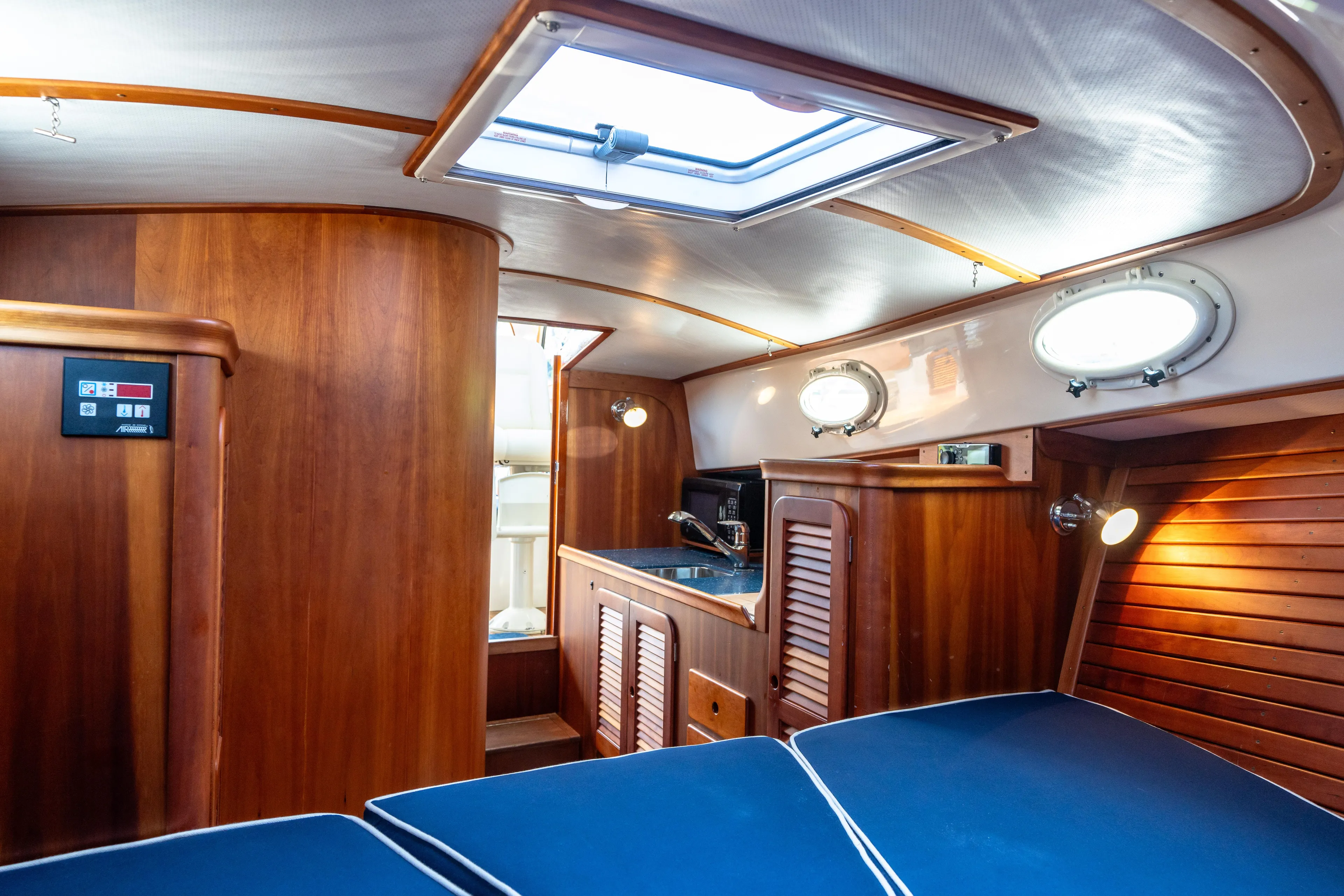 Sometimes Yacht Photos Pics Interior of 2007 Hinckley Picnic Boat EP with wood paneling and blue seating.