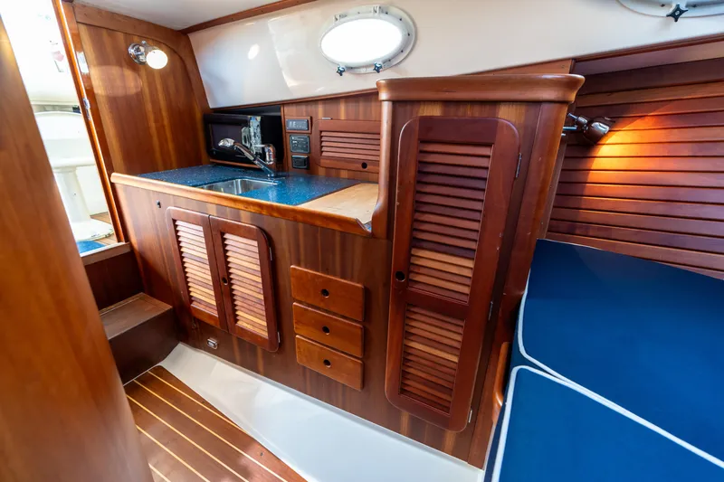 Sometimes Yacht Photos Pics 2007 Hinckley Picnic Boat EP interior with wooden cabinetry and blue seating.