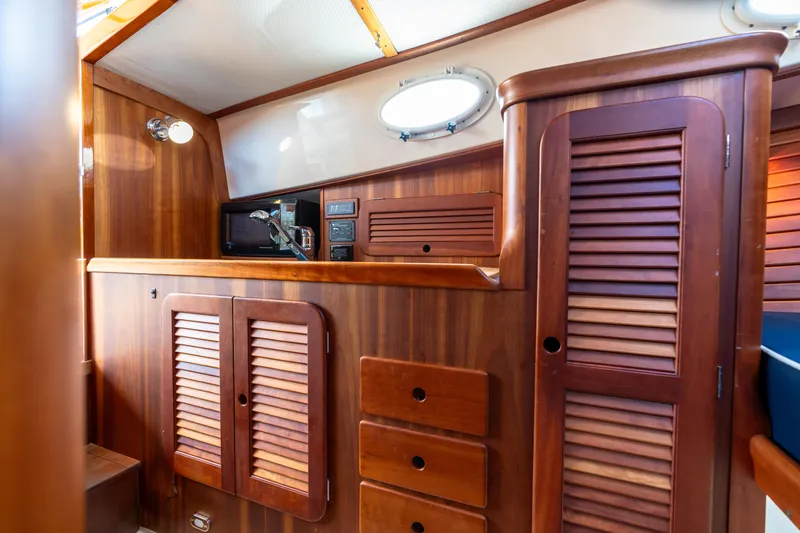 Sometimes Yacht Photos Pics Hinckley Picnic Boat EP 2007 interior with wooden cabinetry and porthole window.