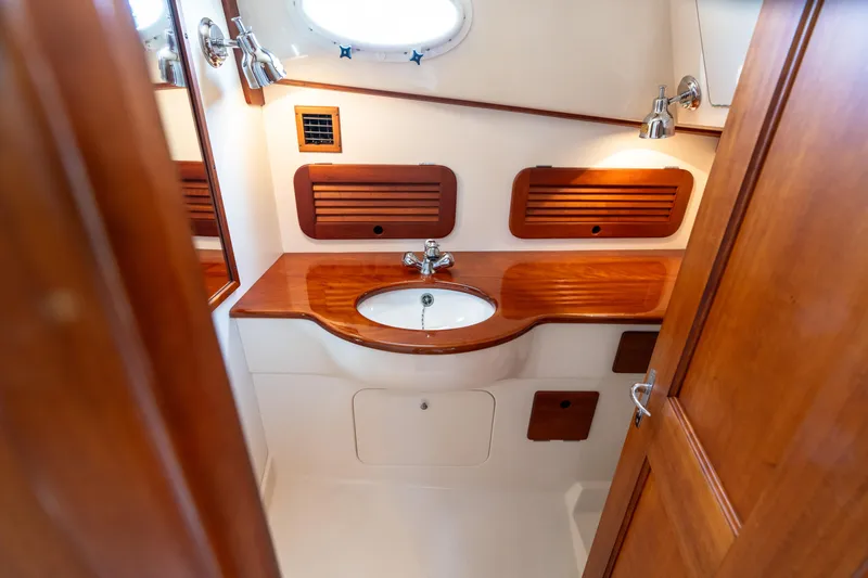 Sometimes Yacht Photos Pics Luxurious 2007 Hinckley Picnic Boat EP bathroom with wooden accents and modern fixtures.