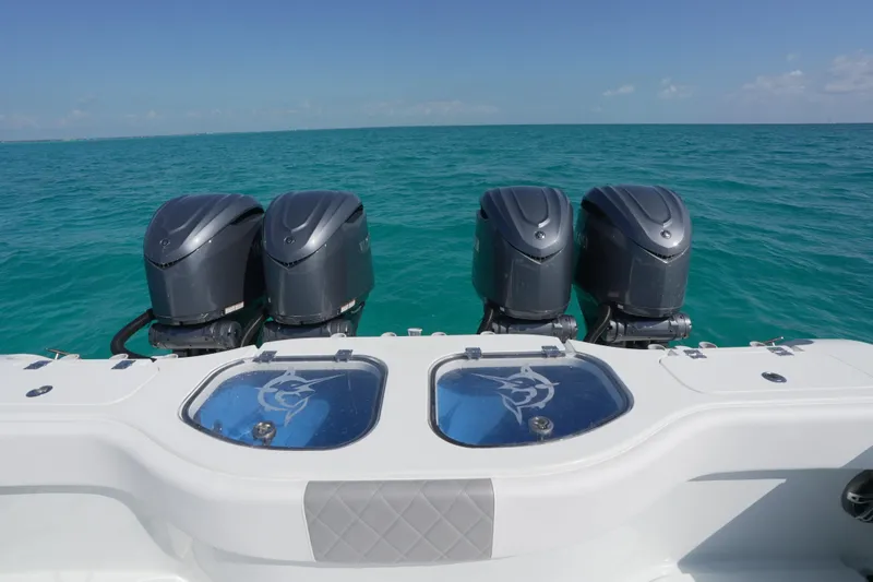  Yacht Photos Pics 2024 Freeman 42 boat with four powerful outboard motors on turquoise ocean water.