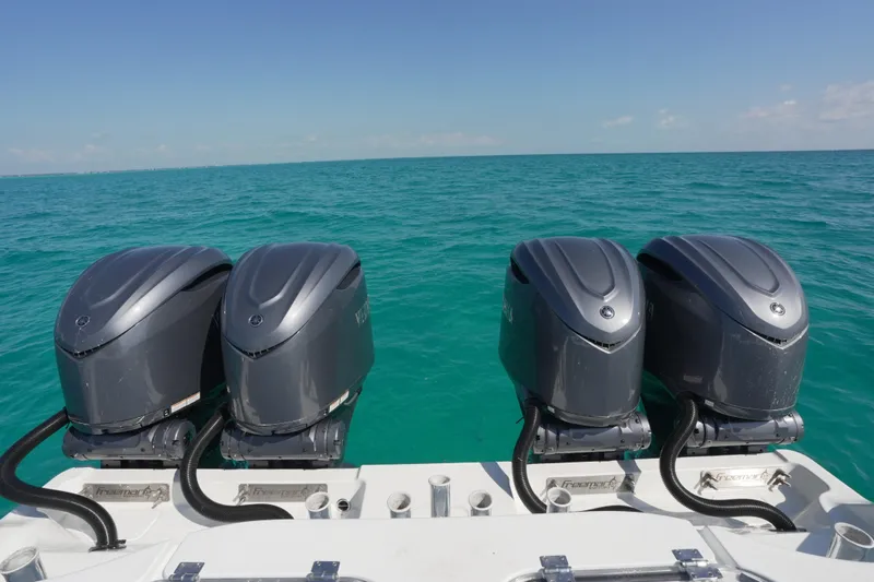  Yacht Photos Pics Four powerful outboard motors on a 2024 Freeman 42 boat, cruising in clear blue waters.