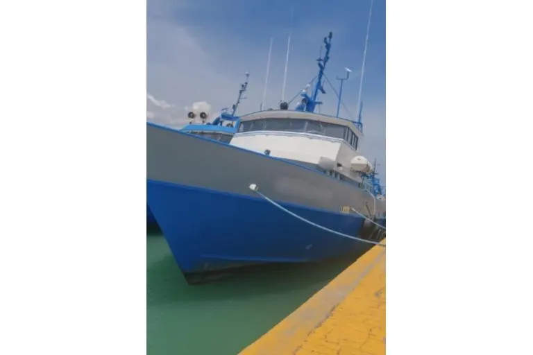  Yacht Photos Pics Custom-built offshore crew vessel docked at a pier, 2004 model, blue and white design.