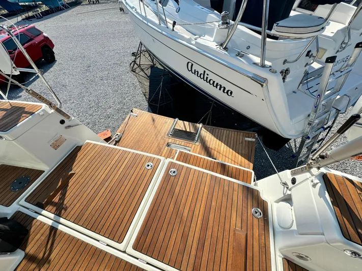 Leopolis Yacht Photos Pics 2019 Jeanneau Sun Odyssey 440 Performance sailboat with teak deck, named Andiamo, in a marina.