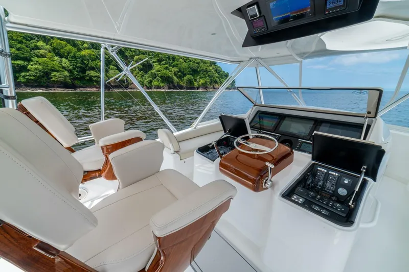 Galati Yacht Sales Trade Yacht Photos Pics 2021 Viking 58 Convertible yacht cockpit with modern controls, luxurious seating, and scenic ocean view.