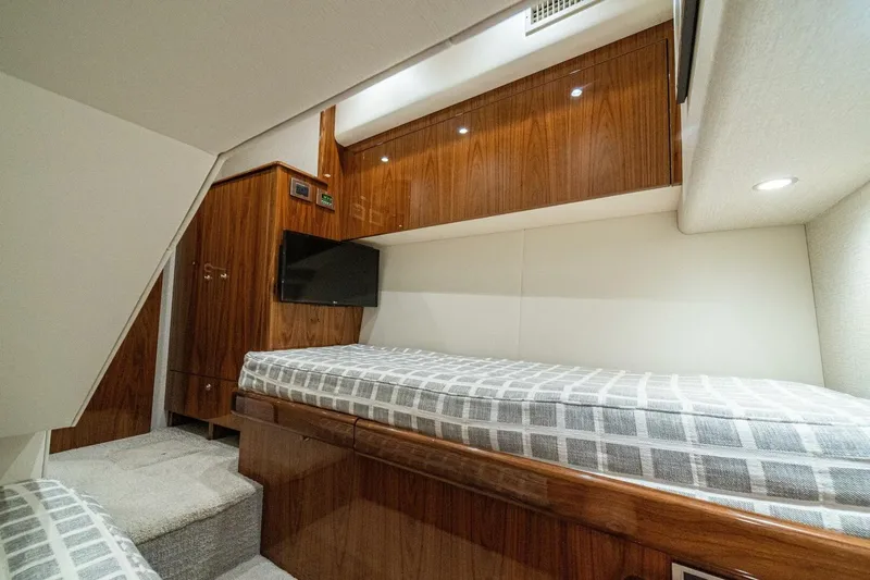 Galati Yacht Sales Trade Yacht Photos Pics 2021 Viking 58 Convertible yacht cabin with wood paneling and cozy bedding.