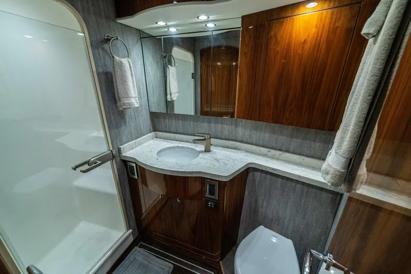 Galati Yacht Sales Trade Yacht Photos Pics Luxurious bathroom in 2021 Viking 58 Convertible yacht with modern fixtures and elegant wood finishes.