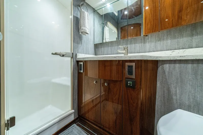 Galati Yacht Sales Trade Yacht Photos Pics Luxurious bathroom in 2021 Viking 58 Convertible yacht with modern fixtures and wood cabinetry.