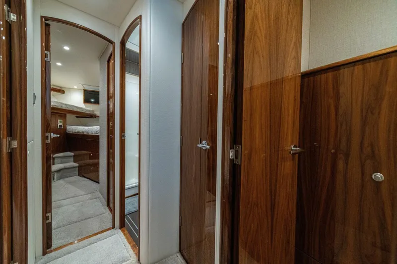 Galati Yacht Sales Trade Yacht Photos Pics Interior hallway of 2021 Viking 58 Convertible yacht with wooden doors and carpeted flooring.