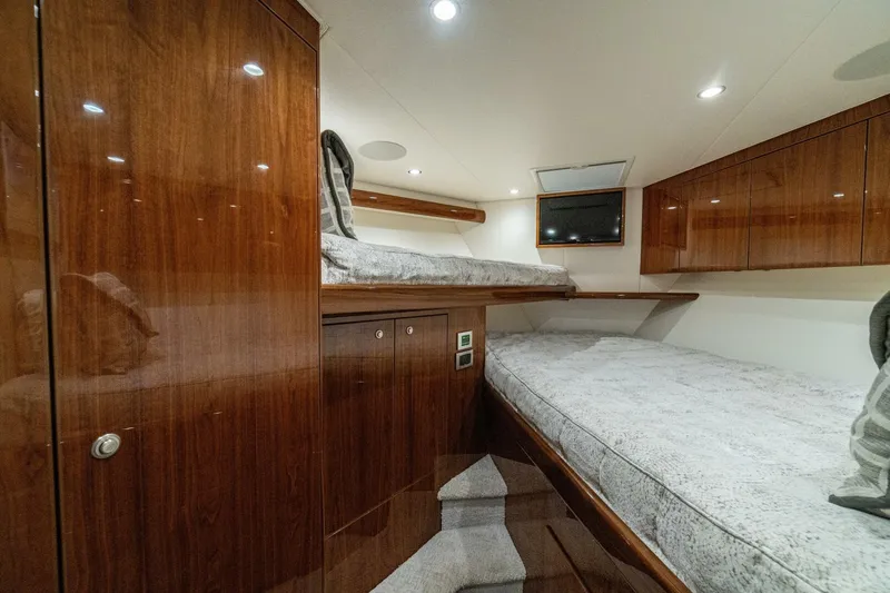 Galati Yacht Sales Trade Yacht Photos Pics Luxurious cabin interior of 2021 Viking 58 Convertible yacht with wooden finishes and cozy bedding.