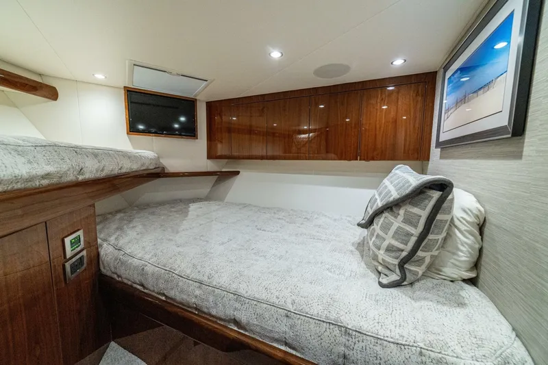 Galati Yacht Sales Trade Yacht Photos Pics Cozy cabin interior of 2021 Viking 58 Convertible yacht with plush bedding and modern decor.