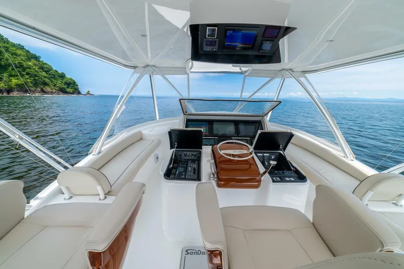 Galati Yacht Sales Trade Yacht Photos Pics 2021 Viking 58 Convertible yacht helm with ocean view and lush coastline.