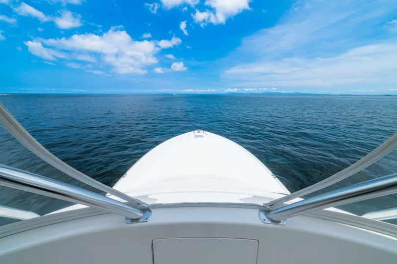 Galati Yacht Sales Trade Yacht Photos Pics Bow view of 2021 Viking 58 Convertible yacht on open sea under blue sky.