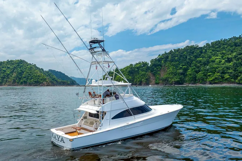 Galati Yacht Sales Trade Yacht Photos Pics 2021 Viking 58 Convertible yacht cruising near lush green islands under a partly cloudy sky.