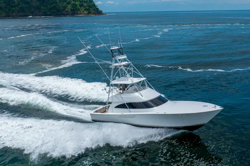 Galati Yacht Sales Trade Yacht Photos Pics 2021 Viking 58 Convertible yacht cruising on open water, surrounded by lush coastline.