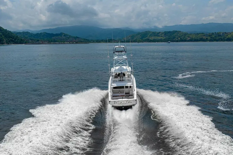 Galati Yacht Sales Trade Yacht Photos Pics 2021 Viking 58 Convertible yacht cruising on open water with scenic mountain backdrop.