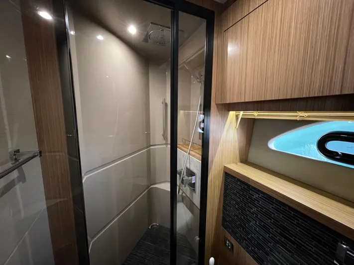Kings' Ransom Yacht Photos Pics Luxurious bathroom interior of 2017 Sea Ray L590 Fly yacht with modern shower and wood accents.
